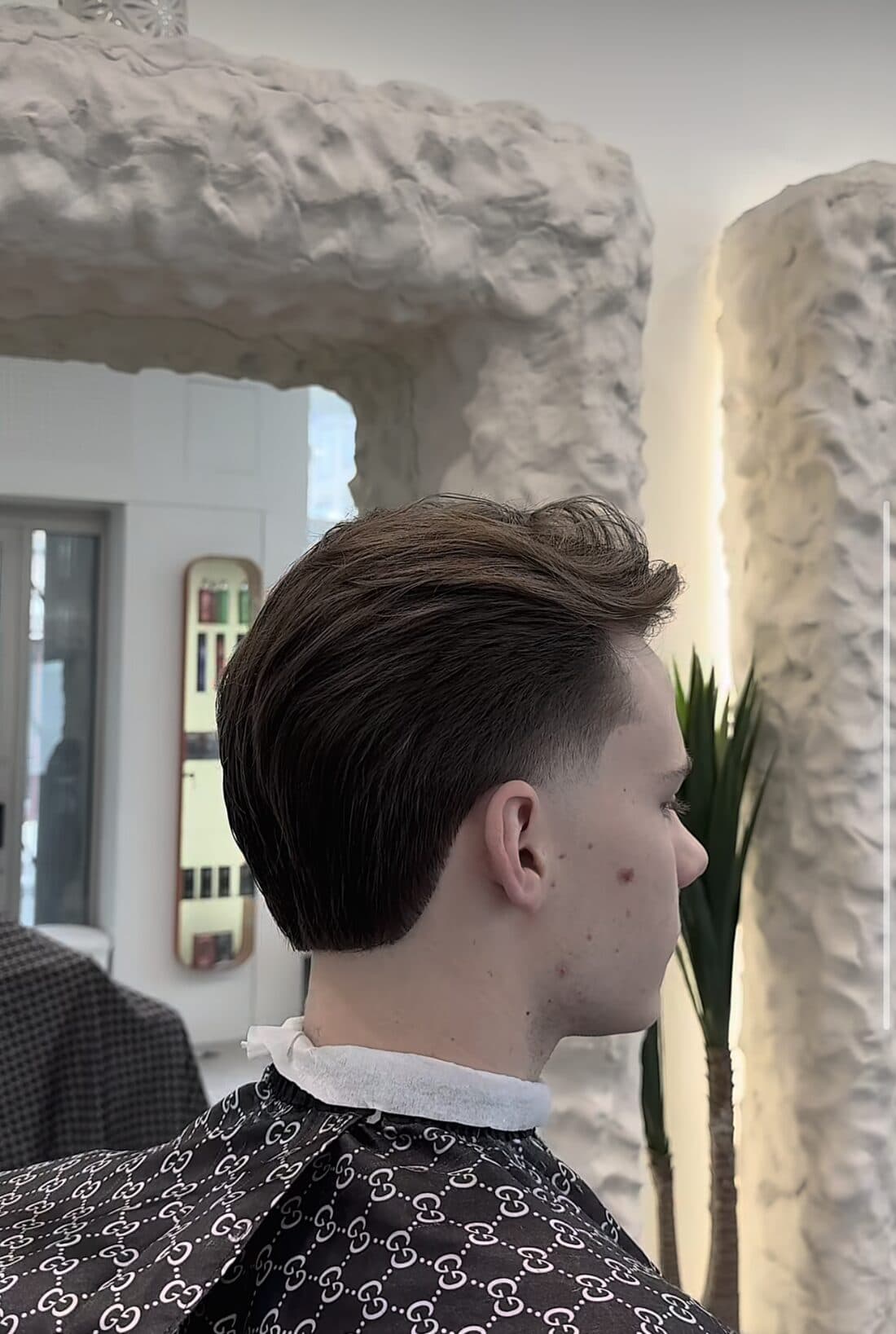 Coupe homme classique avec taper sur les côtés, dans le miroir du salon