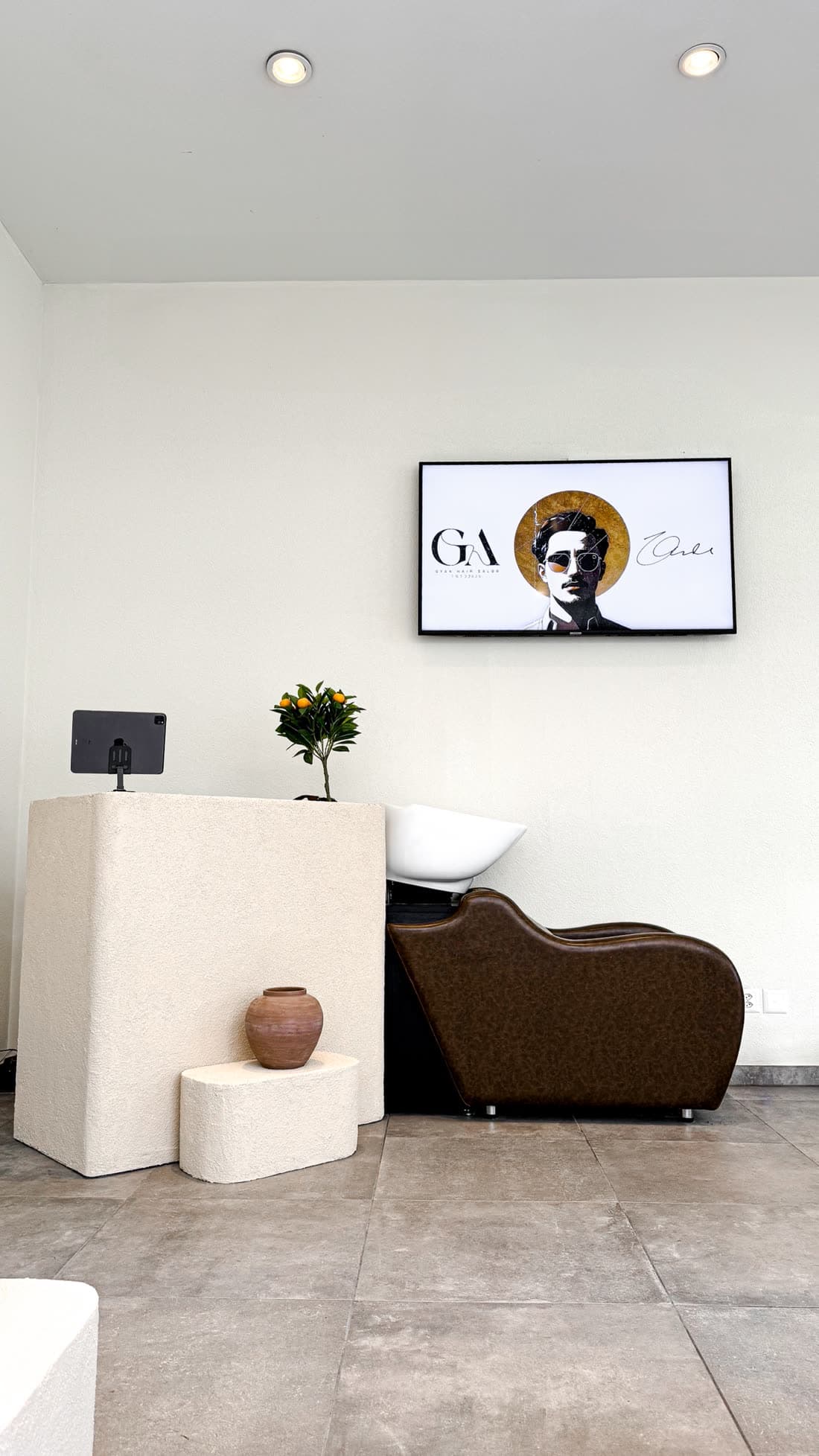 Accueil de GYAN Hair Salon avec bac à shampoing et logo GYAN à l'écran