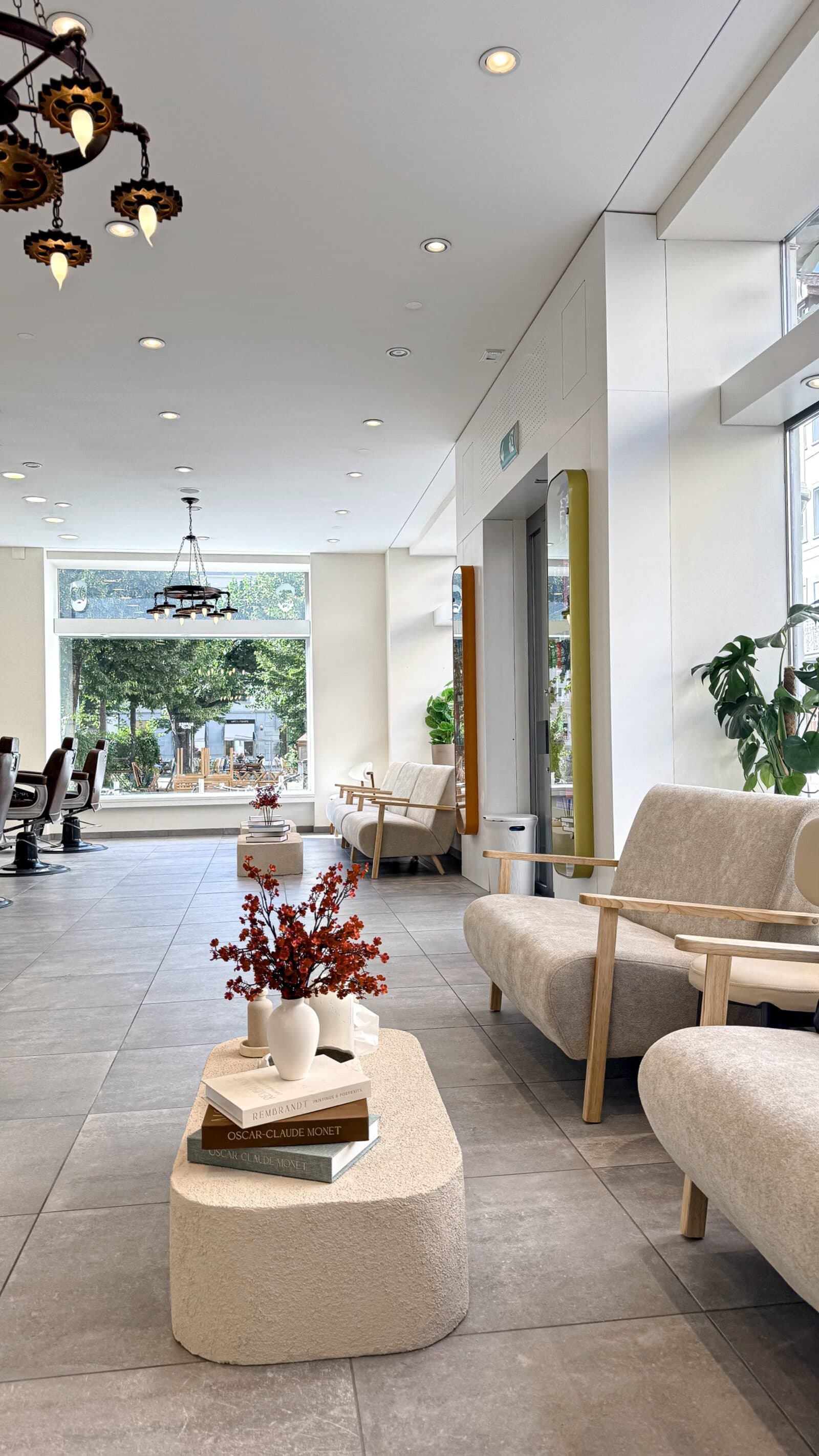 Salon lumineux à la Zentralstrasse à Bienne avec lounge, miroirs et fauteuils de barbier