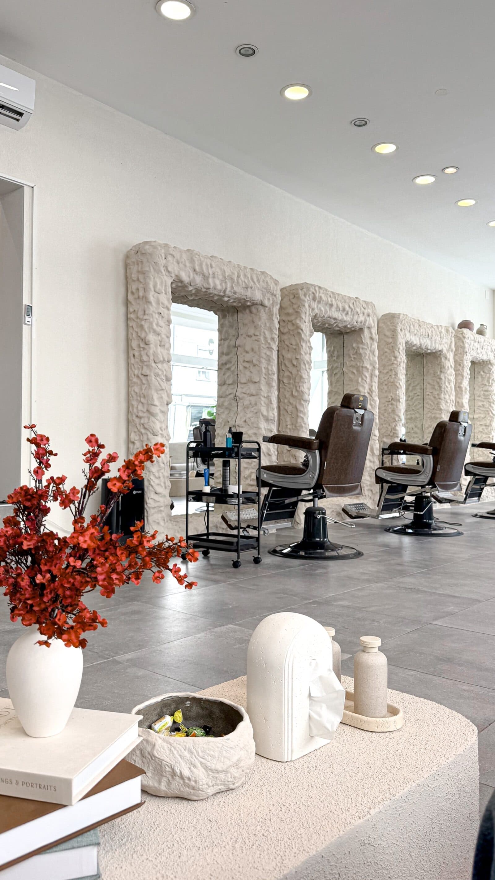 Miroirs sculpturaux et fauteuils de barbier chez GYAN Hair Salon à Bienne